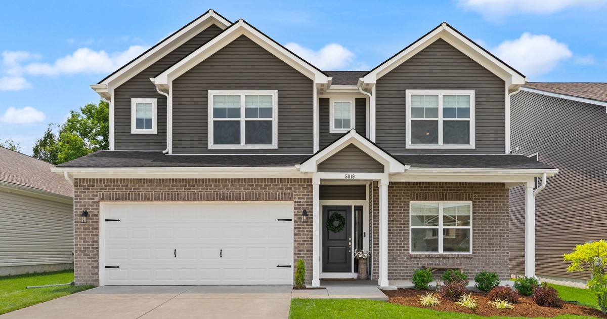 Two-story home with gray siding, brick front and two-car garage in Floyds Knobs, Indiana